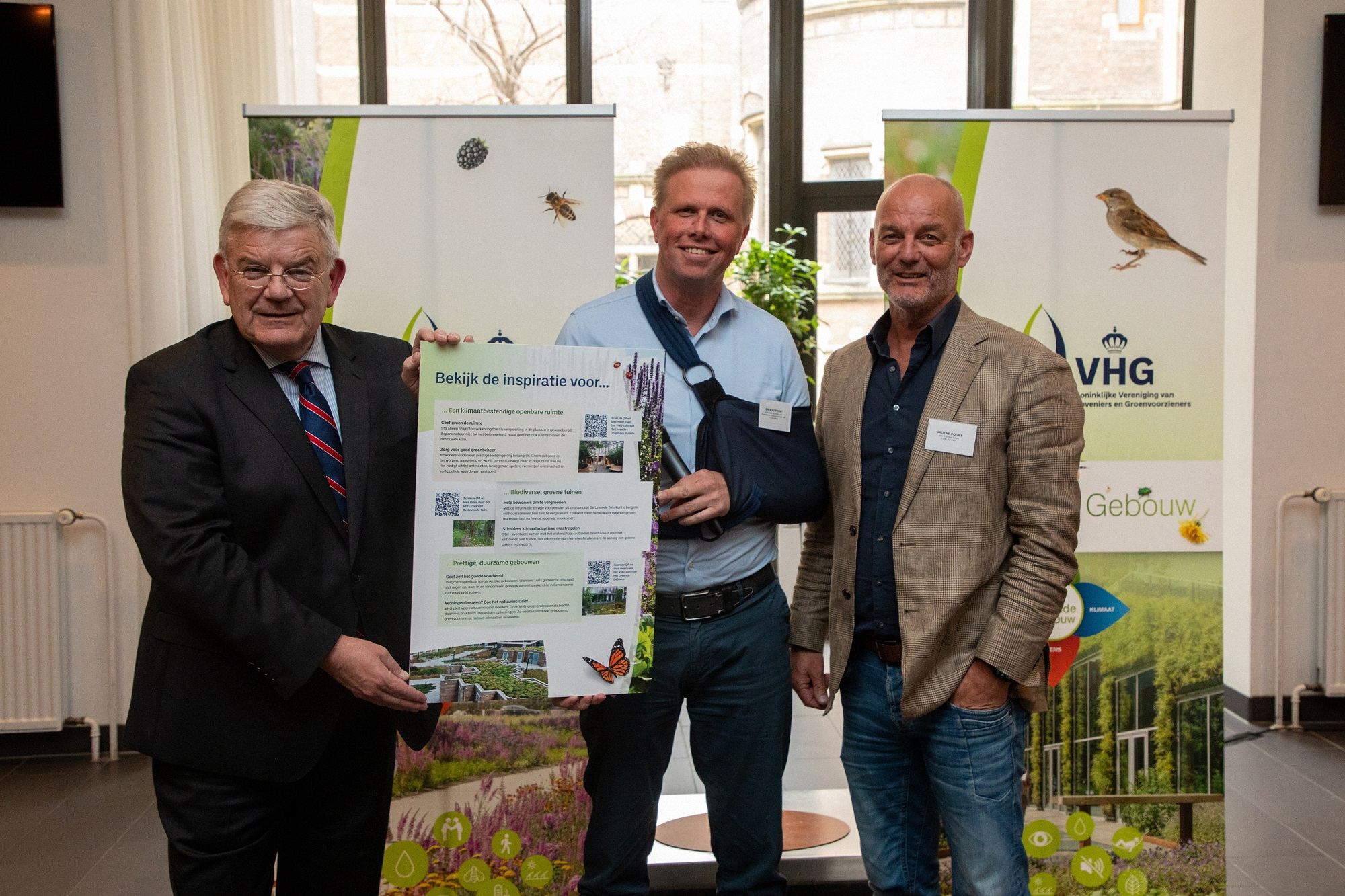 Foto: Jan van Zanen (links) neemt het VHG-pamflet ‘Het dorp en de stad van de toekomst 